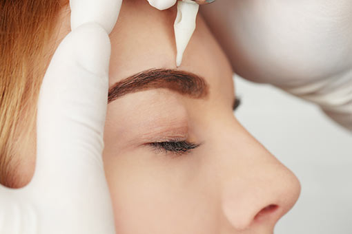 jeune femme en séance de maquillage permanent des sourcils L’implant de sourcil - micropigmentation des sourcils